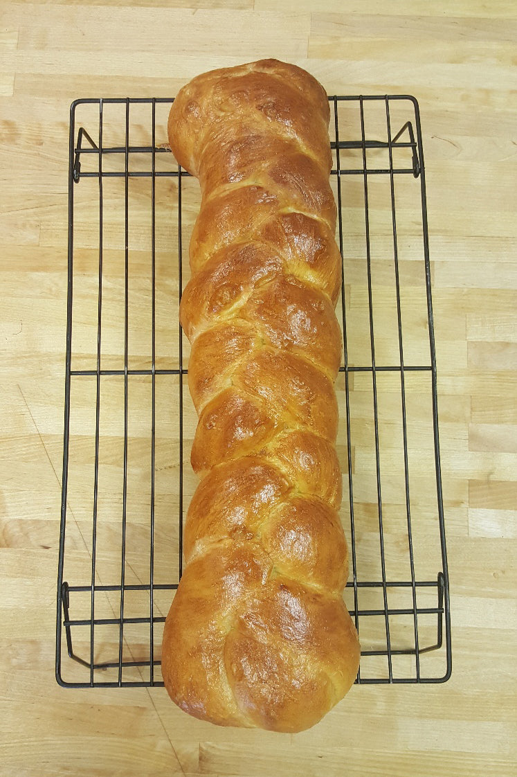 3 strand braided challah on cooling rack