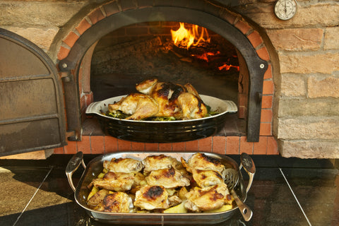 Chicken on a bed of vegetables made in a wood-fired oven