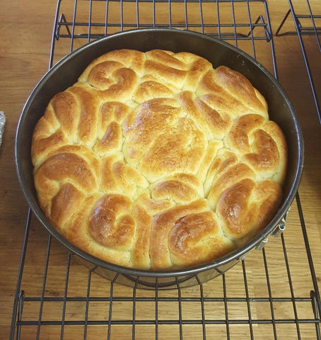 baked brioche in a spring form pan on a cooling rack
