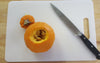 mini pumpkin with the top cut off knife and cutting board