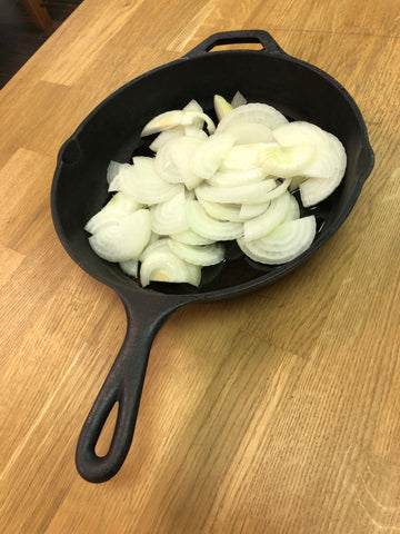 Raw onions in cast iron pan 