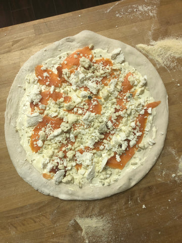 Uncooked Smoked salmon pizza with goat cheese and honey