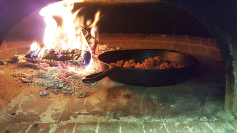sausage cooking in a wood fired oven