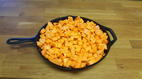 raw sweet potatoes in an iron skillet