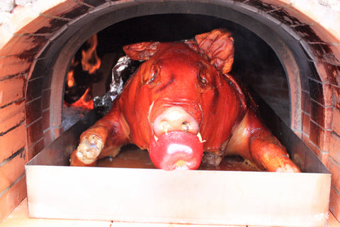 Roasting a whole pig in a wood-fired brick oven
